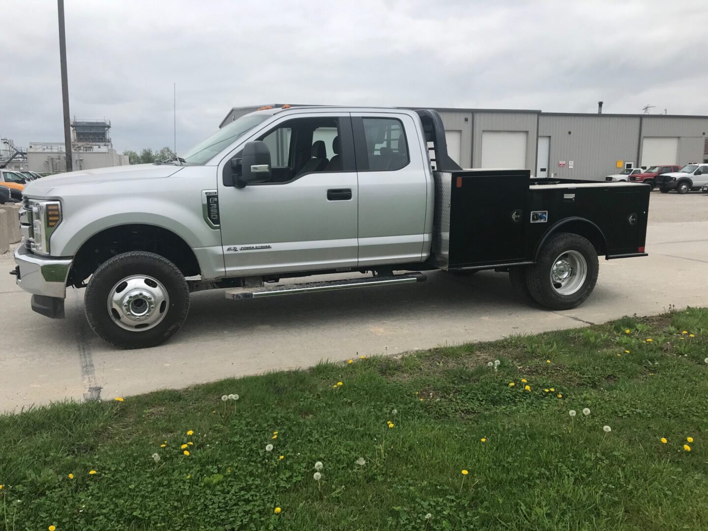 A silver truck with its flatbed on the side