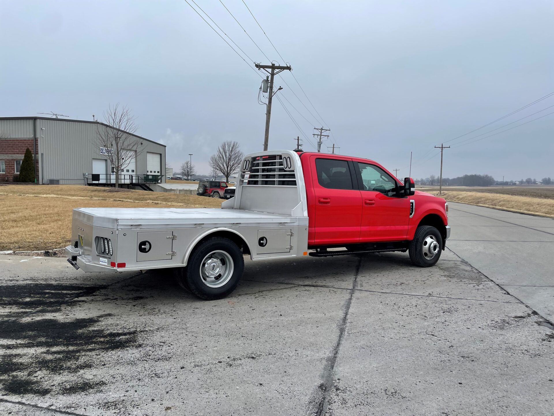 A red truck parked in the middle of a parking lot.